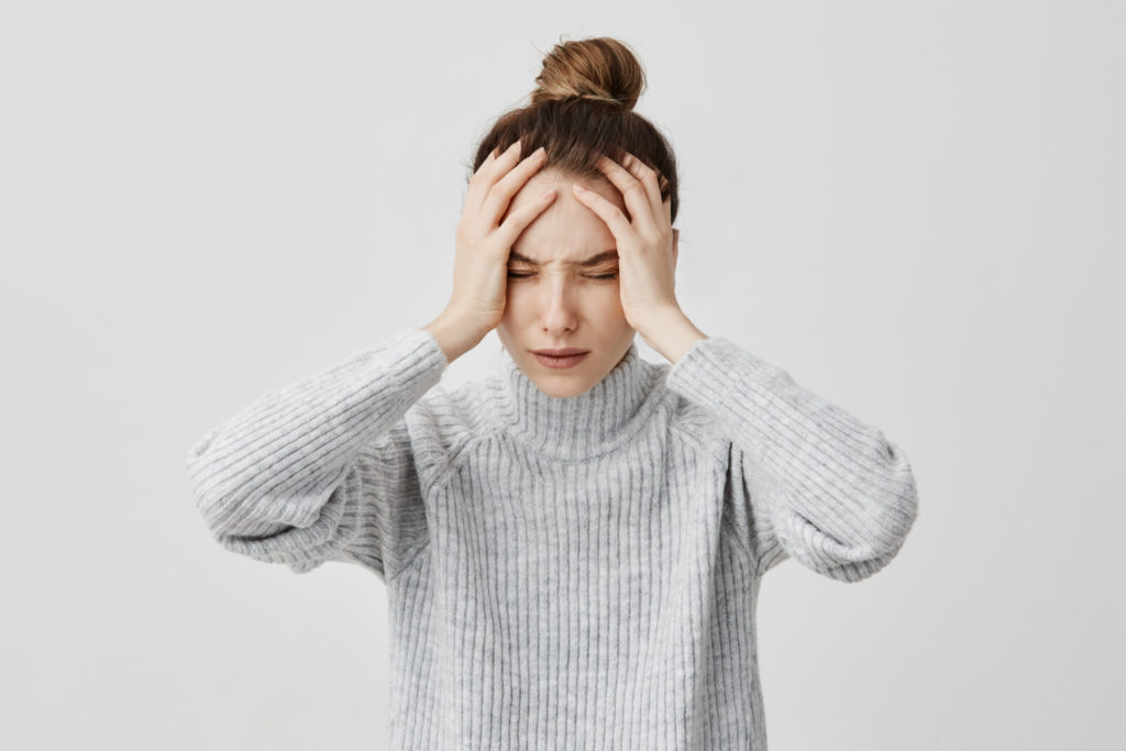 a young woman stressed out and holding her head